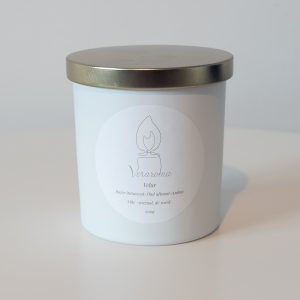 Lumânare parfumată Veraroma, model Velur la 200g, în recipient alb închis cu capac auriu. Arome de bujor întunecat, oud afumat și ambră.